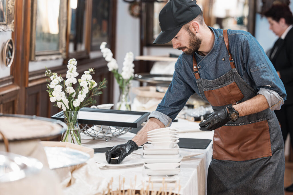 Chef arranges plates on the elegant restaurant table.