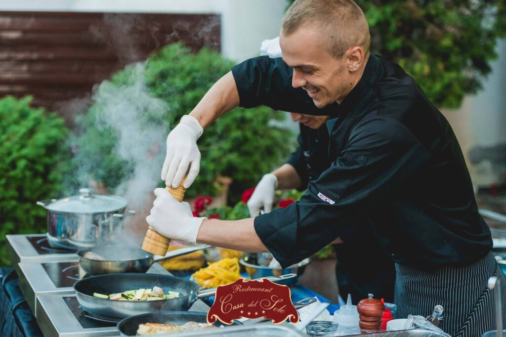 Chef seasoning food at a restaurant.